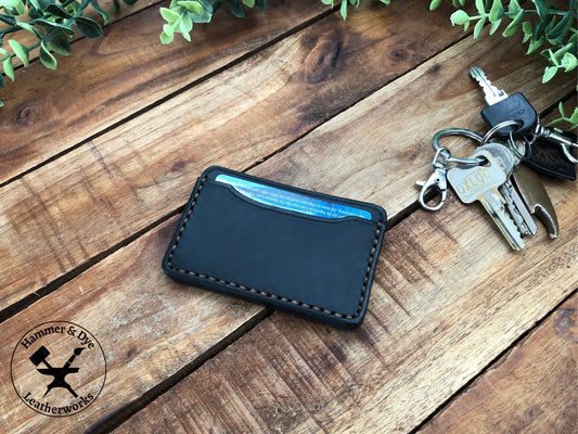 Handmade Minimalist Black Leather Card Wallet next to keys on a desk
