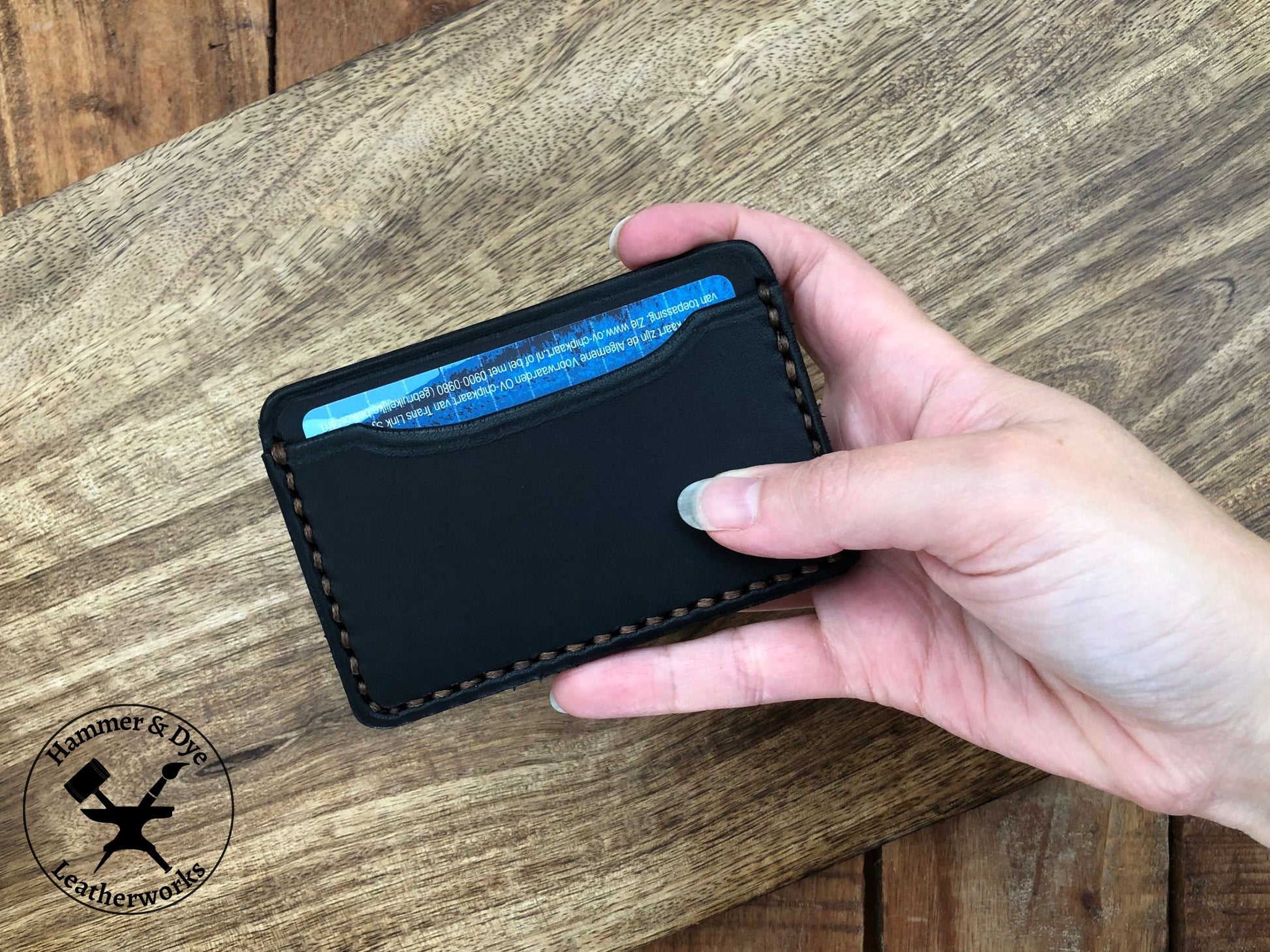 Handmade Minimalist Black Leather Card Wallet held in a hand