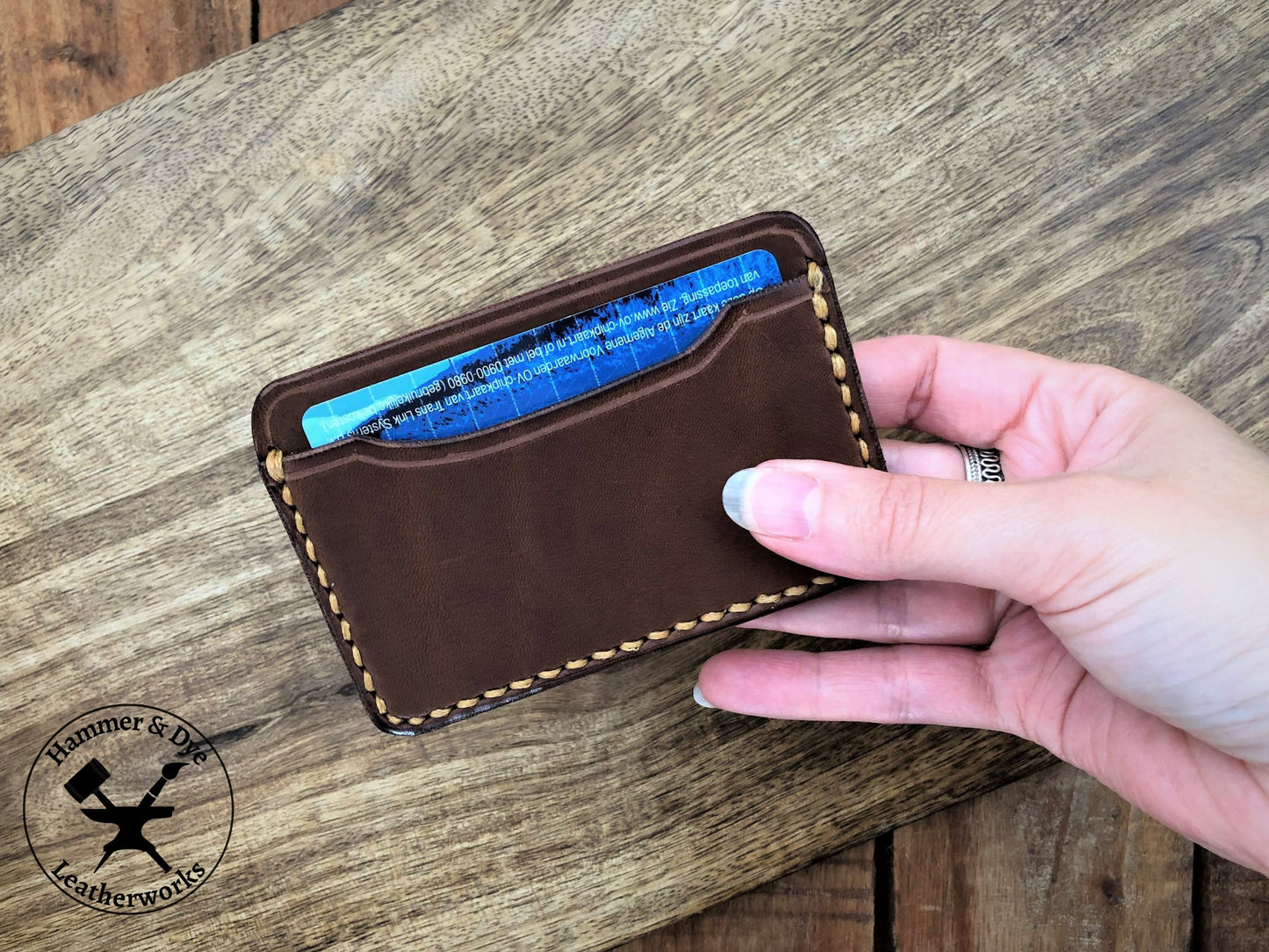 Handmade Minimalist Brown Leather Card Wallet with Hazel Stitching close up in a hand