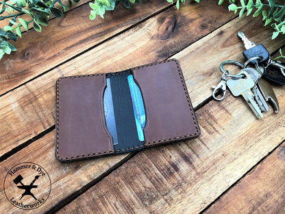 Handmade Two-tone Bifold Leather Card Wallet in Black and Brown with brown stitching next to a bunch of keys