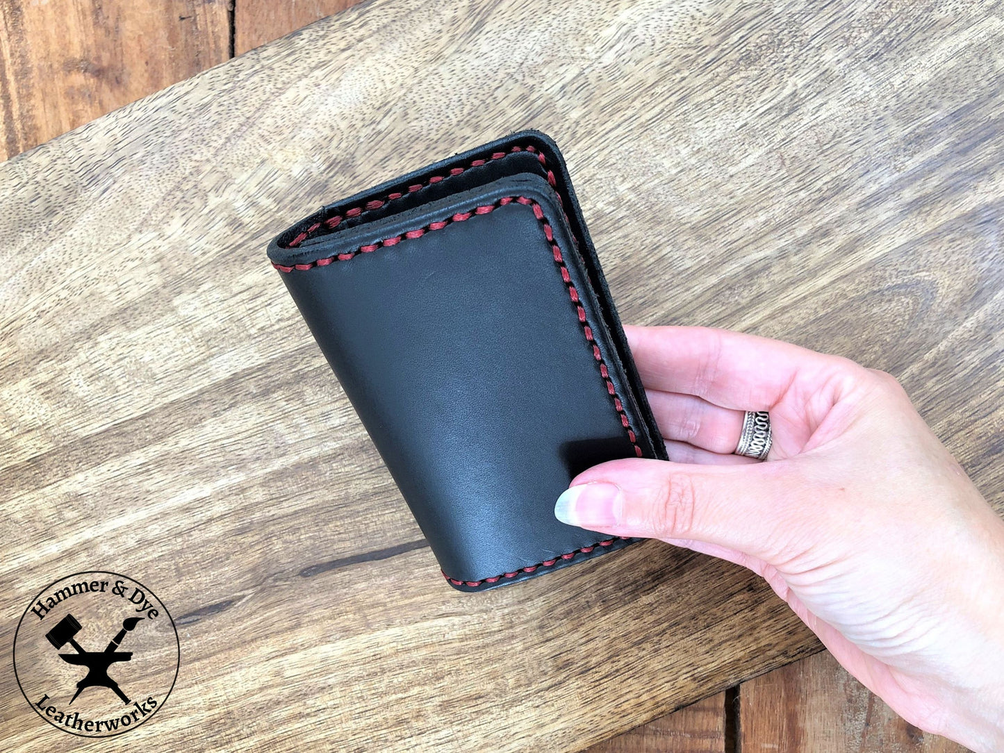 Handmade Black Bifold Leather Card Wallet held in a hand