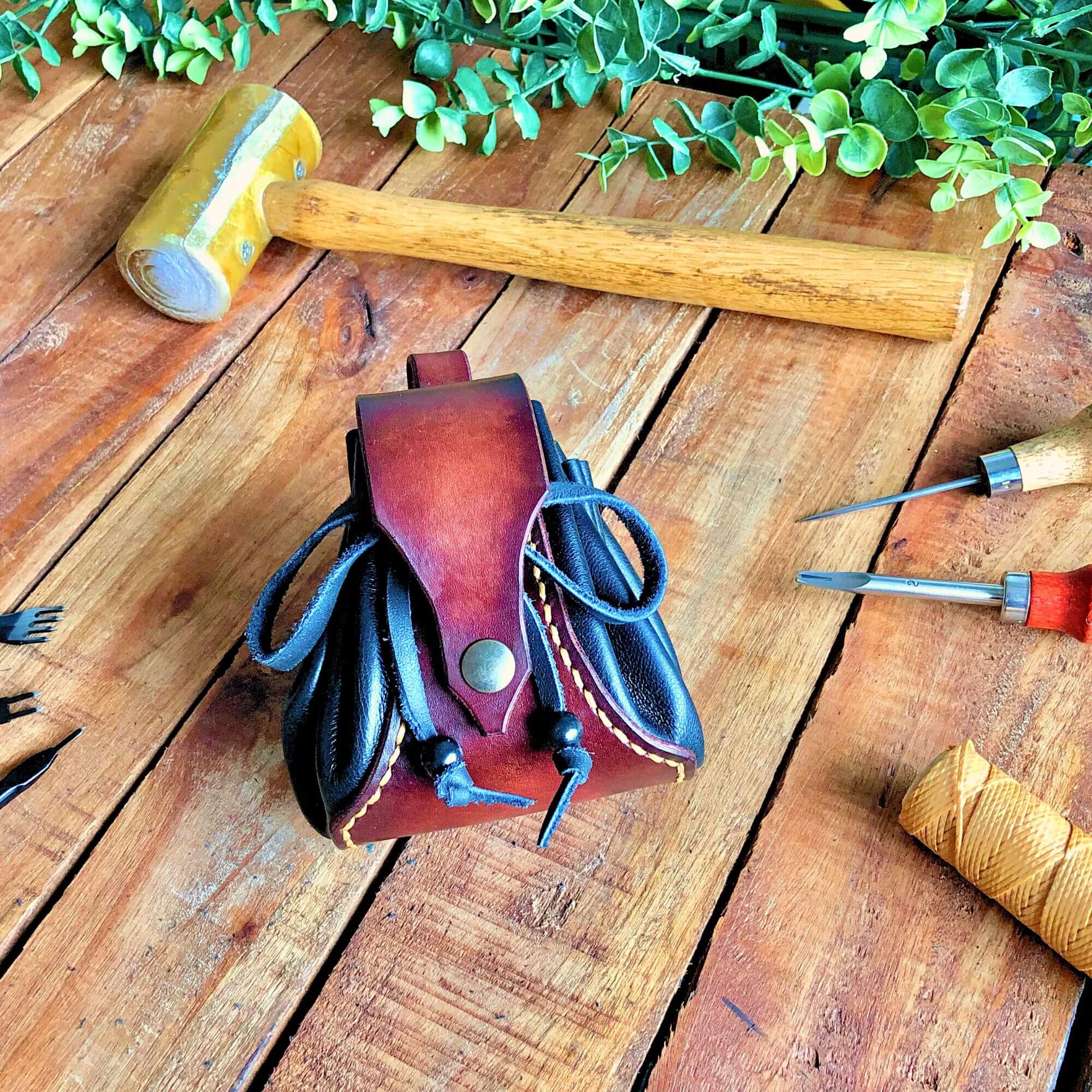 a leather drawstring dice surrounded by leathercraft toolspouch