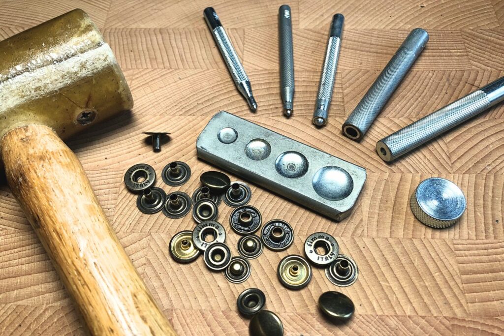 The Beginner's Leathercraft Tool Guide 7 leathercraft guides: how to set snaps in leather tools: snap setter kit, snaps and a mallet.