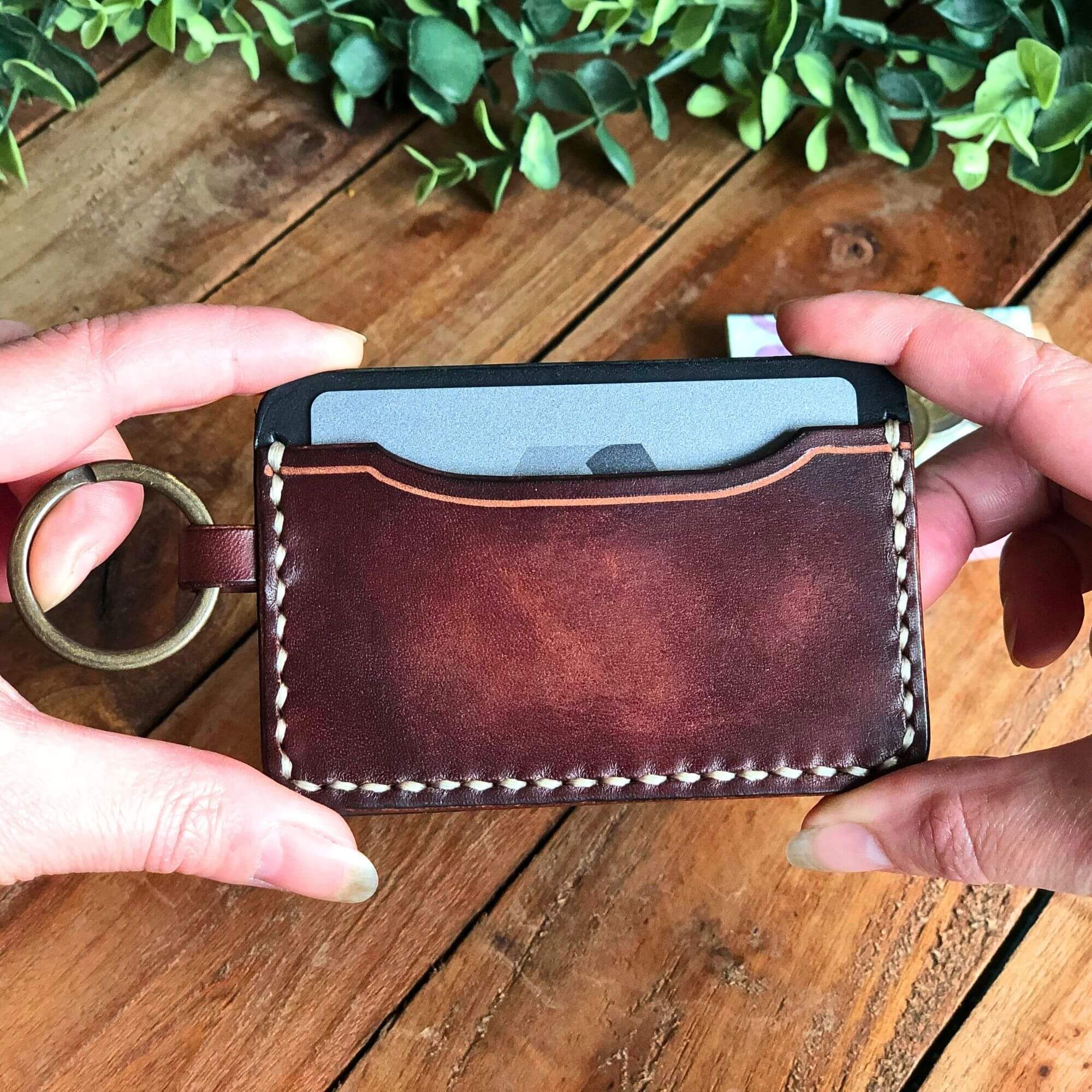 Small Wallet Bundle 13 brown leather keychain card wallet held in two hands