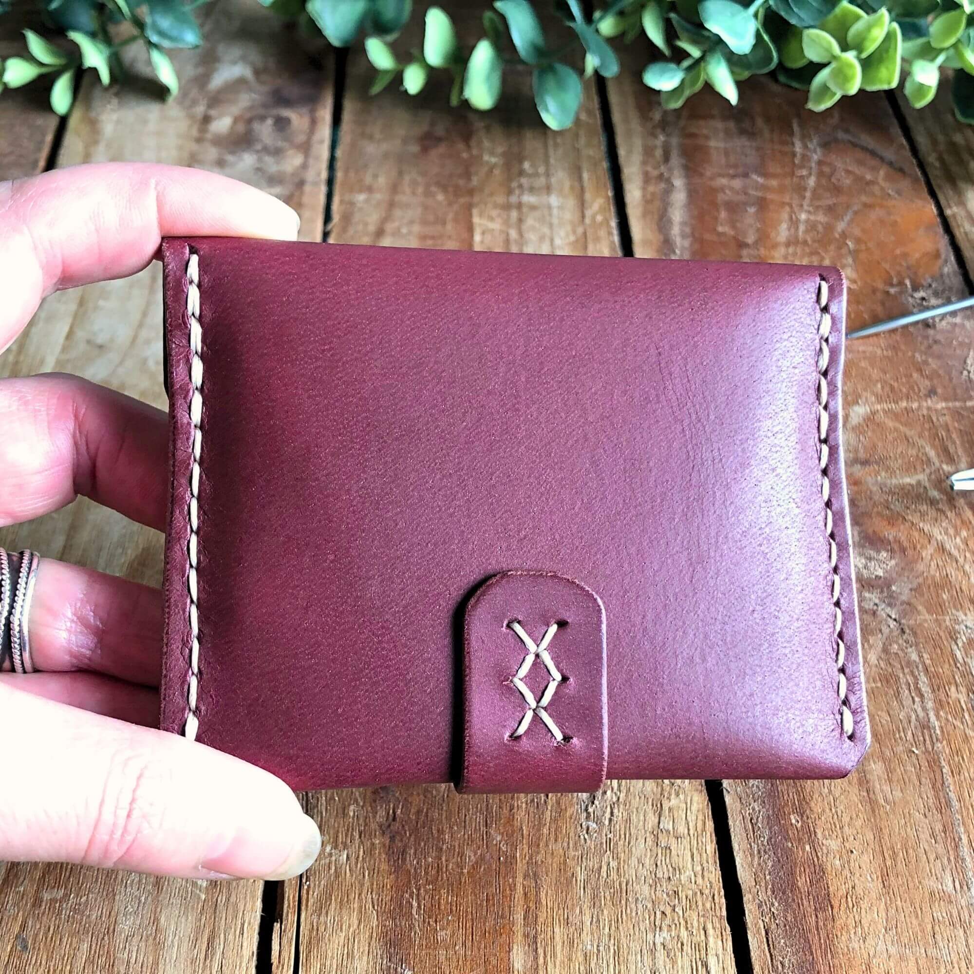 stitching detail on a magenta leather card wallet