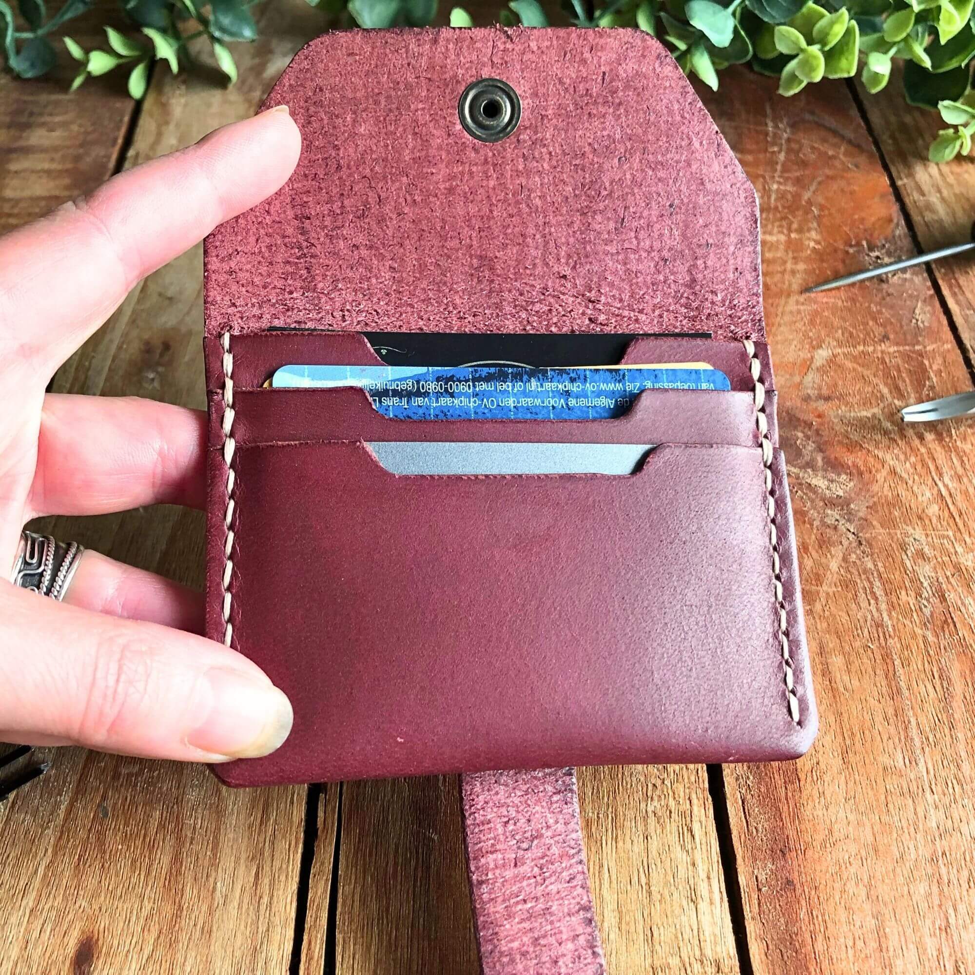 magenta leather card wallet filled with cards held open