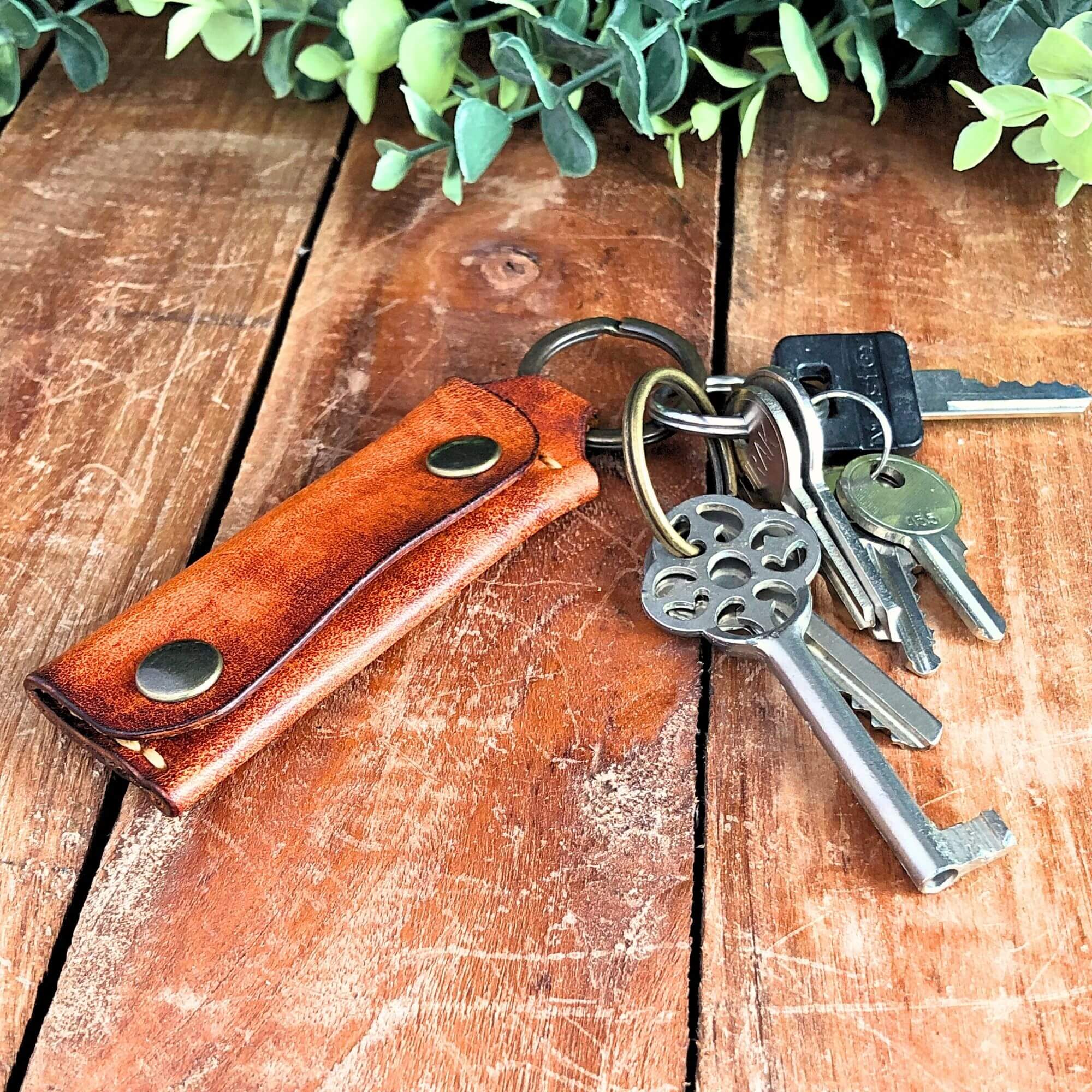 Emergency Keychain Wallet 2 brown leather emergency keychain wallet attached to keys on a rustic wooden background