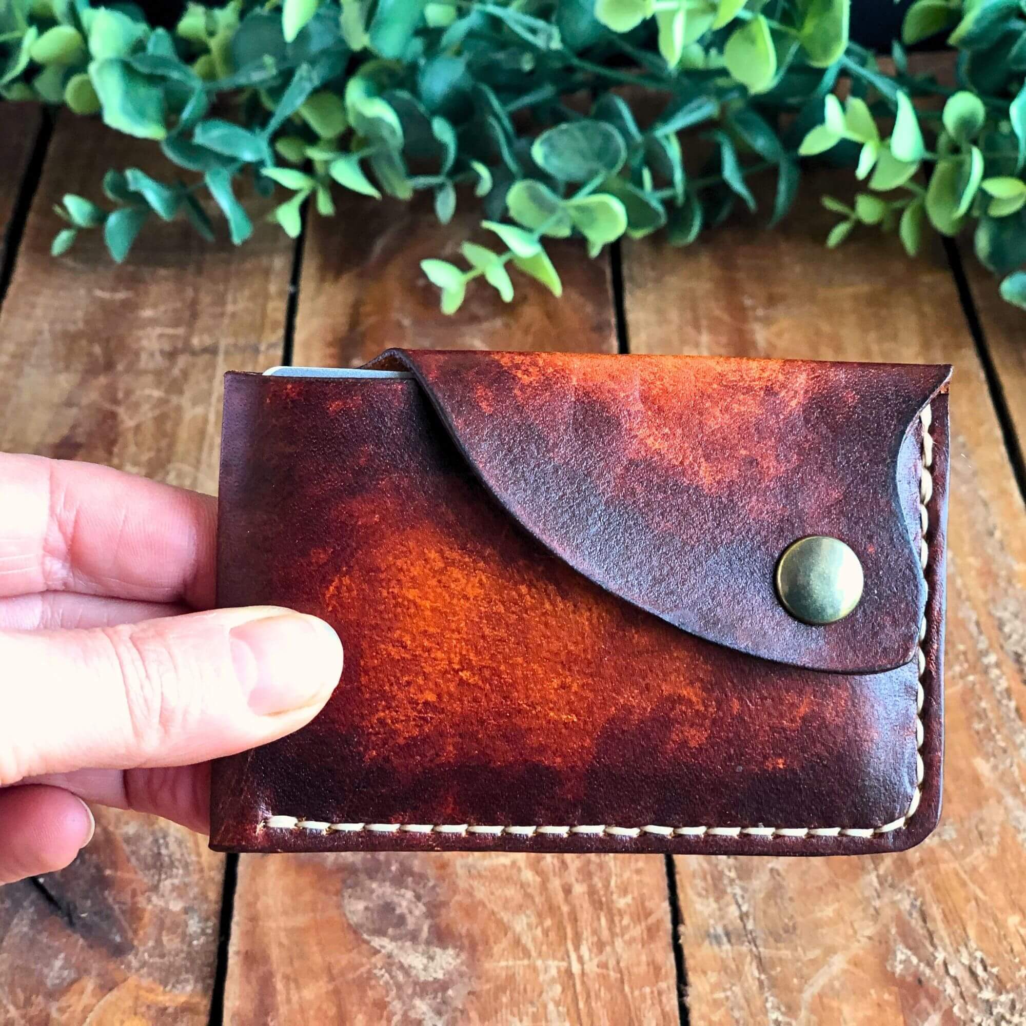 brown minimalist leather card wallet held in hand
