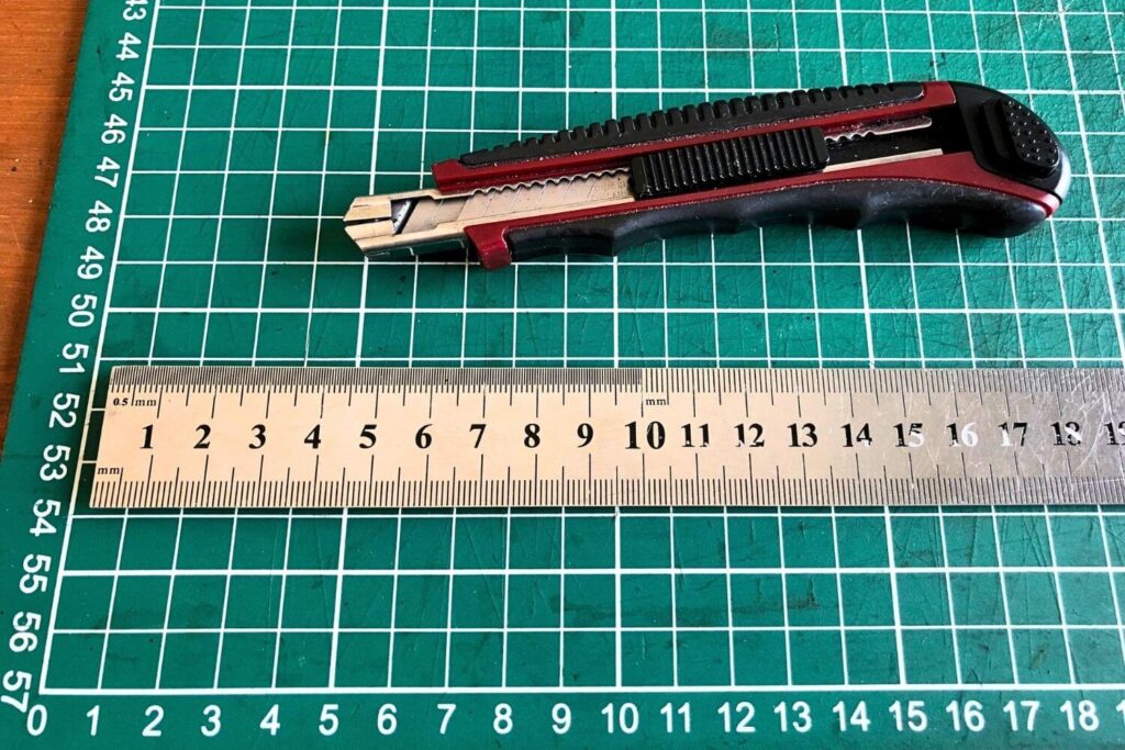 The Beginner's Leathercraft Tool Guide 2 Leathercraft knife with a steel ruler on a self-healing cutting mat.