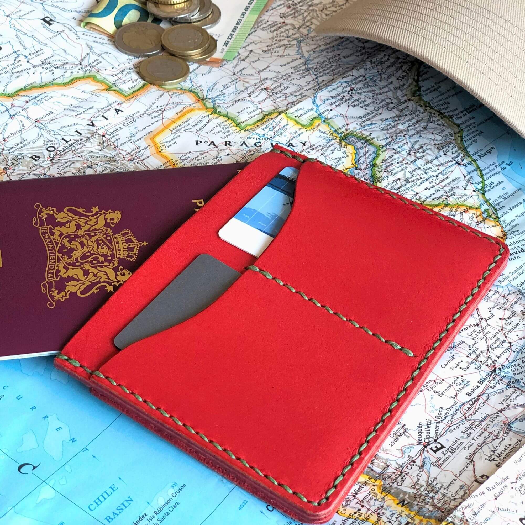 Compact Passport Cover 1 Red leather passport wallet with travel items on a worldmap