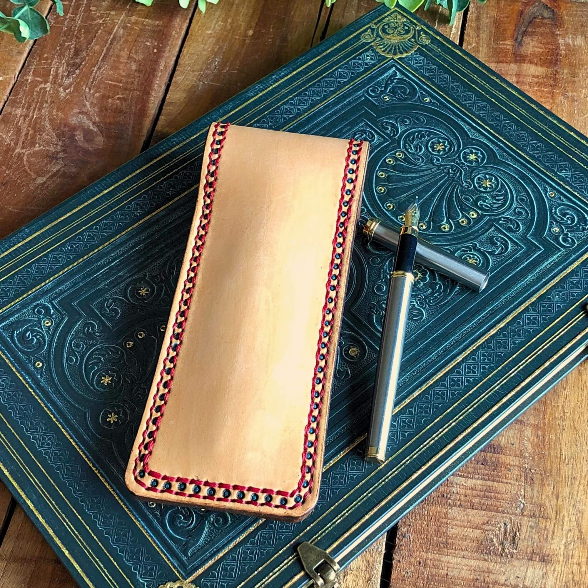 Leather Pen pouch with decorative stitching with a pen and a notebook