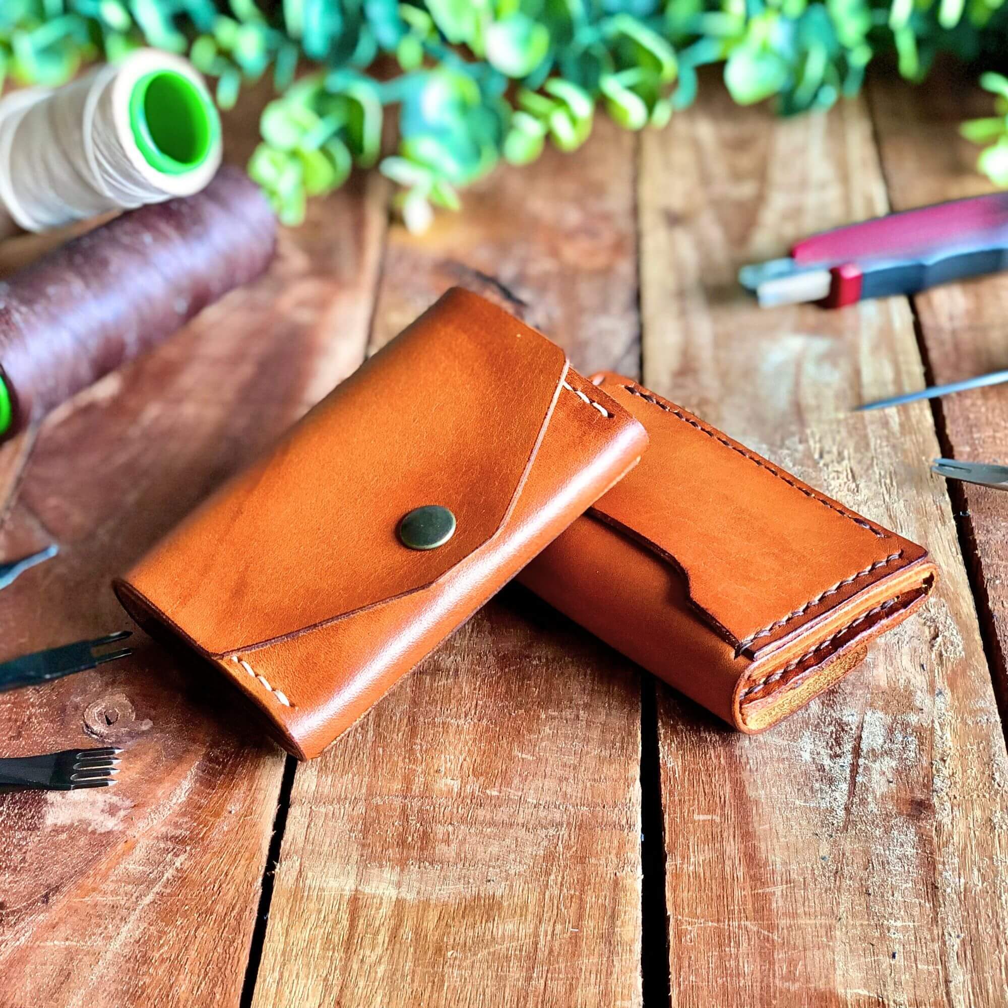 Small Wallet Bundle 5 Handcrafted tan leather wallet with a coin pocket surrounded by leathercraft tools